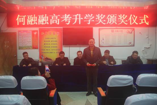 教育局全体干部职工出席颁奖仪式,局长陈林静向何明英同志颁发5000元